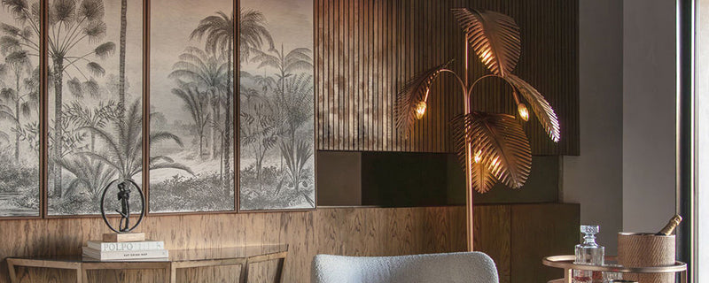 An unusual plam leaf floor lamp stands in a dining room