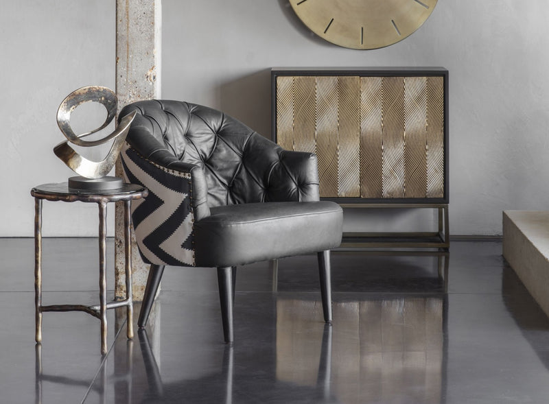 Black accent armchair with a black and white patterned back next to a side table