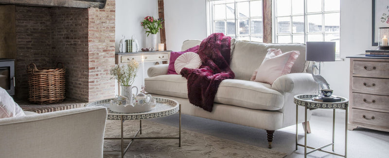 A red sofa throw on a cream sofa in a living room 