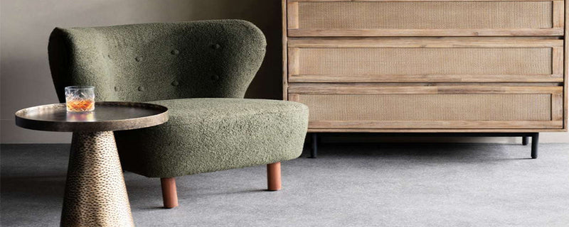 a small round side table sits next to a green armchair