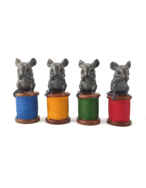 Four small animal figurines on colorful spools of thread 