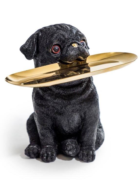 Black dog figurine holding a gold plate 