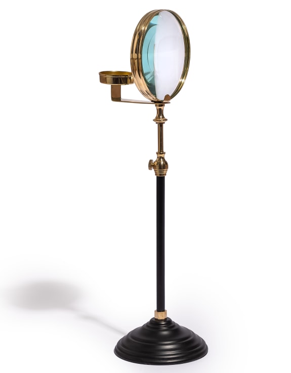 Vintage-style magnifying glass  and candle holder on a stand 