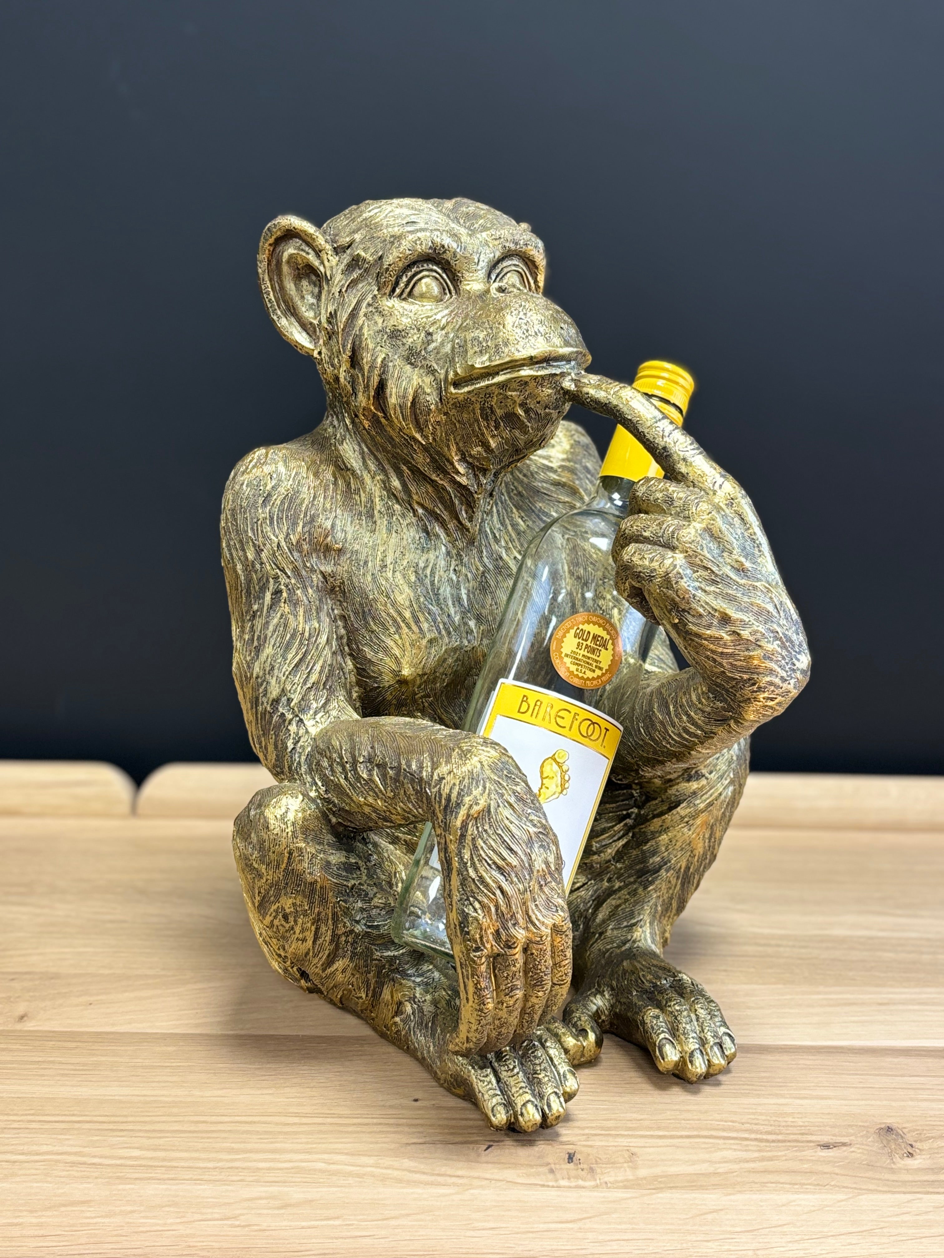 A metallic gold chimpanzee figurine wine bottle holder.