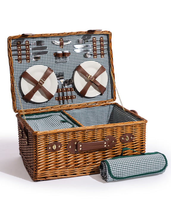 Wicker picnic basket with checkered interior, plates, cutlery, and a rolled blanket 