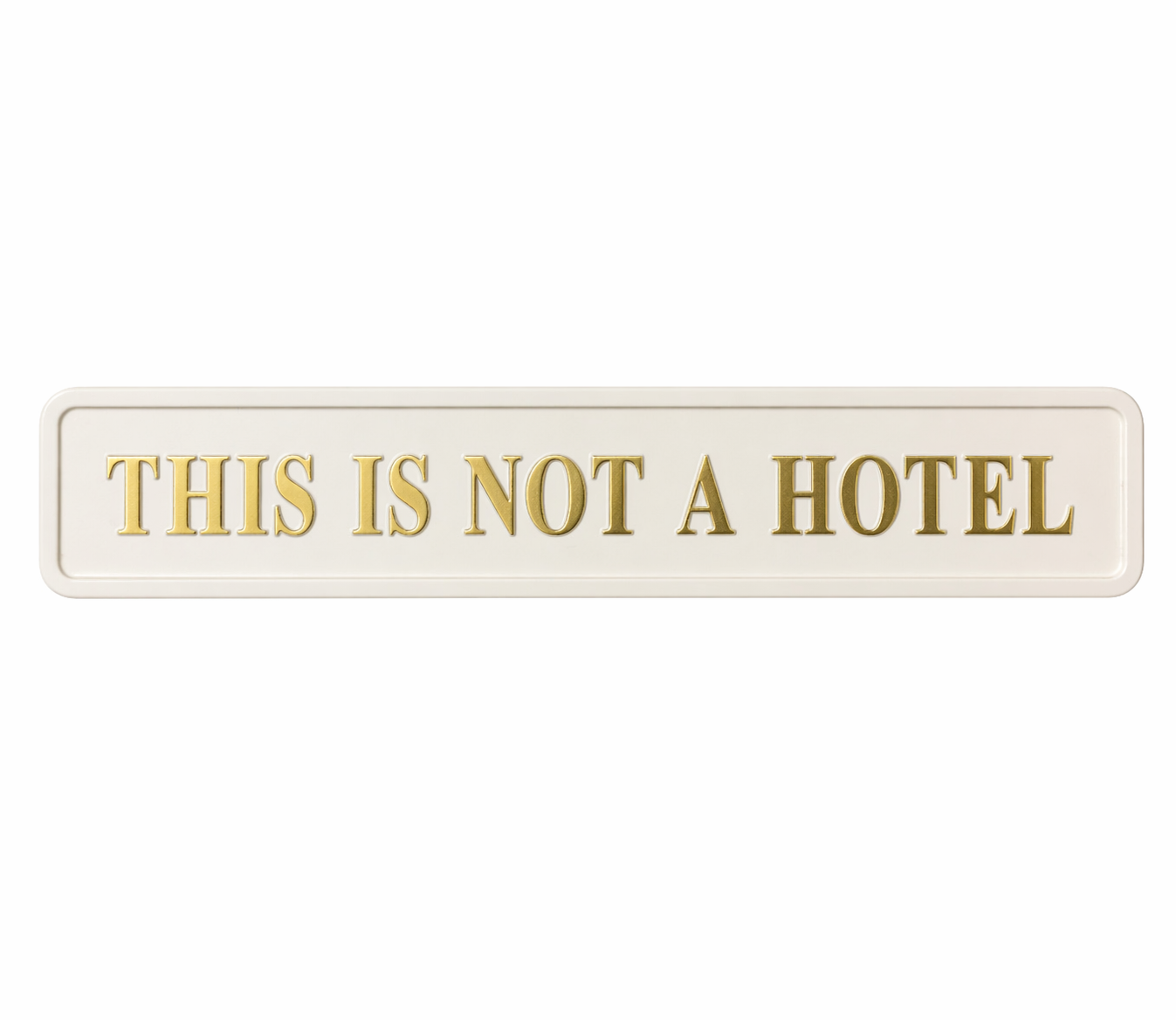 cream wall sign with gold 'this is not a hotel' quote